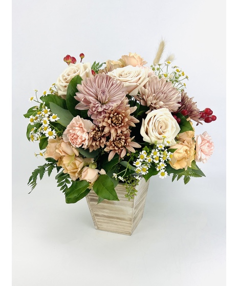 fall-toned floral arrangement in winking head-shaped container