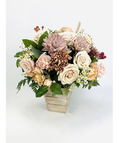 fall-toned floral arrangement in winking head-shaped container