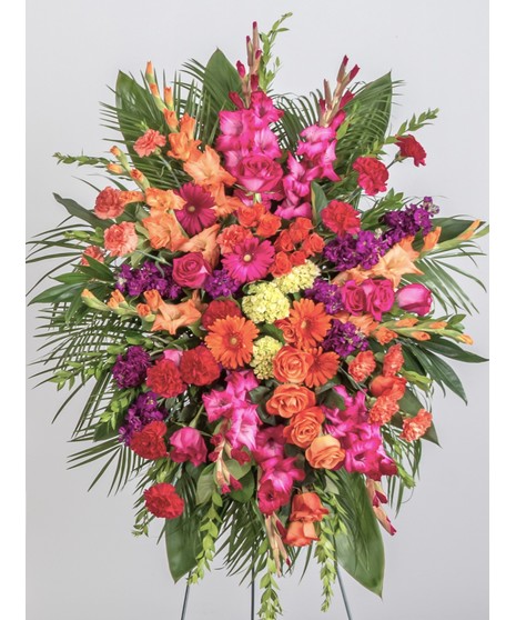 Mix of pink and lavender flowers displayed on an easel stand. Roses, lilies, daisy's and other assorted flowers. Approximate size of  the standard design is 28