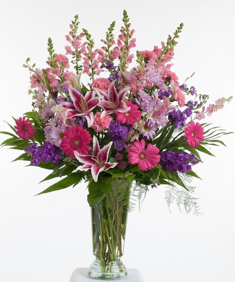 Fresh mix of pink and lavender blooms designed in a glass vase. 