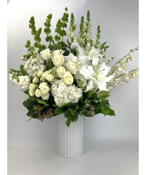 Send all of your Best wishes with this beautiful white and green design which features hydrangea, roses and fragrant lilies in our leaf-wrapped signature clear vase.