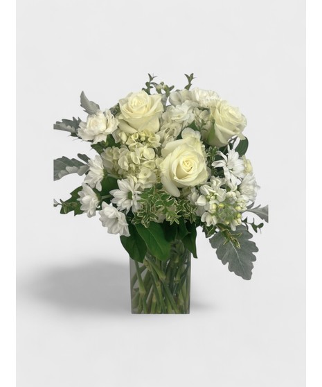 A beautiful mix of roses, lilies, and hydrangea with delicate filler flowers, designed in a clear cube vase.