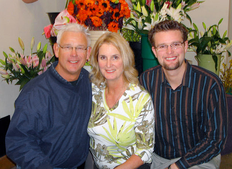 The whole Van Winkle family, posed before a wealth of flowers